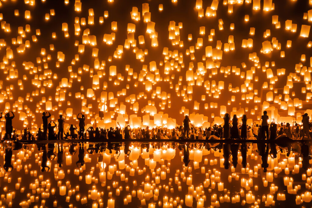 Thai people release sky floating lanterns or lamp to worship Buddha's relics with reflection. Traditional festival in Chiang mai, Thailand. Loy krathong and Yi Peng Lanna ceremony. Celebration.